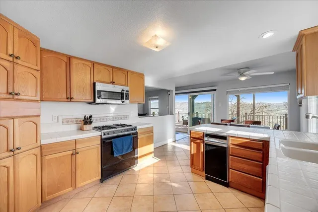 a kitchen with stainless steel appliances granite countertop a refrigerator stove top oven and sink