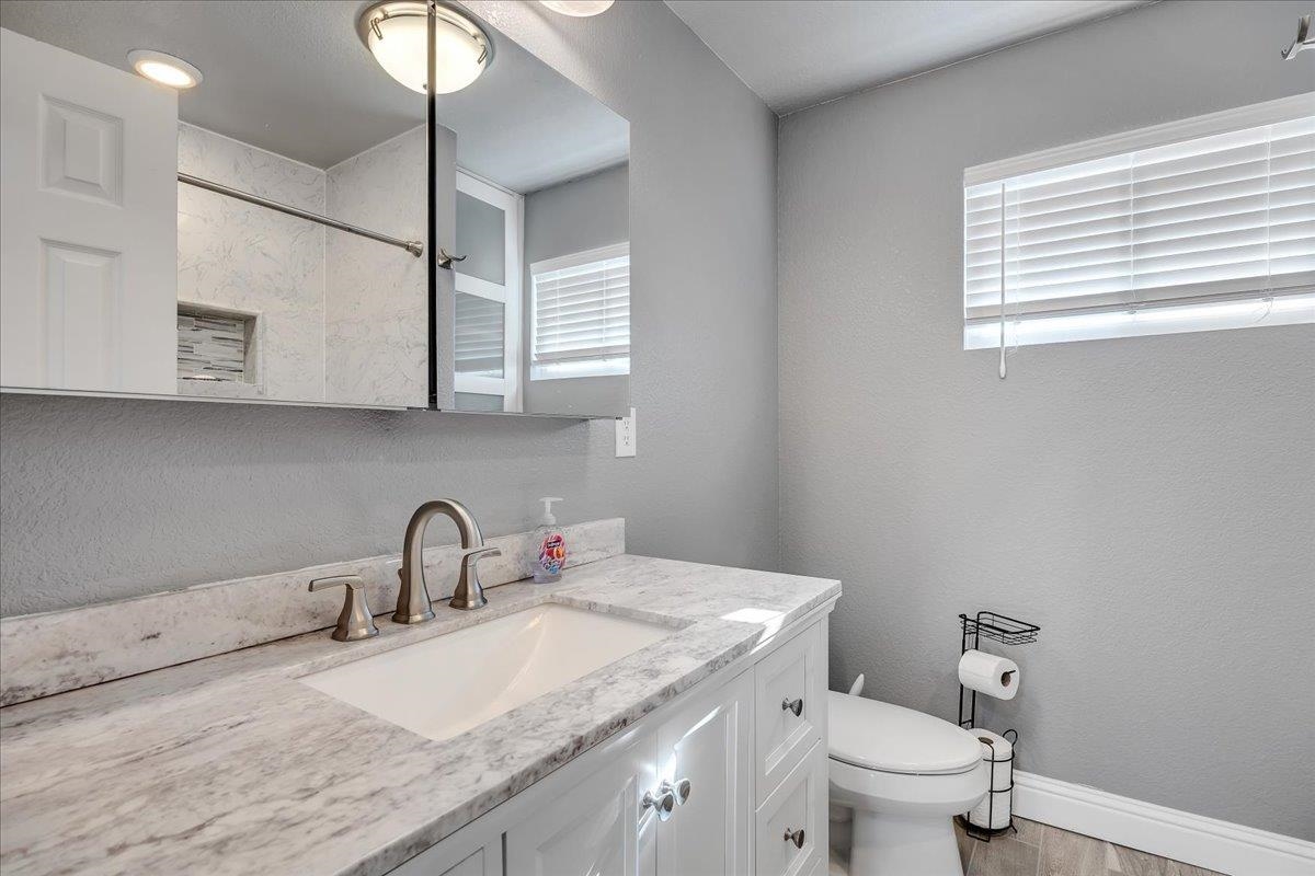 4620 Bayview Drive Copperopolis, CA 95228 - Photo 33 of 59 a bathroom with a granite countertop sink a toilet and a window