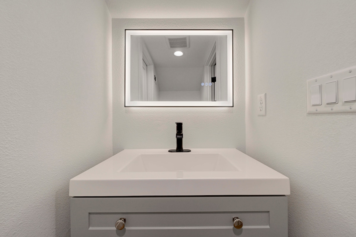 2220 Yellow Jacket Lane, Unit 1 Austin, TX 78741 - Photo 33 of 35 A chic vanity with a modern sink and a sleek, illuminated mirror for everyday elegance.