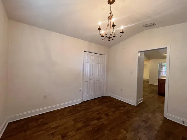 a view of a room with wooden floor and chandelier
