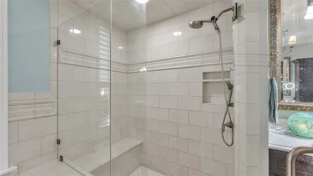 a bathroom with a granite countertop sink a mirror and a shower