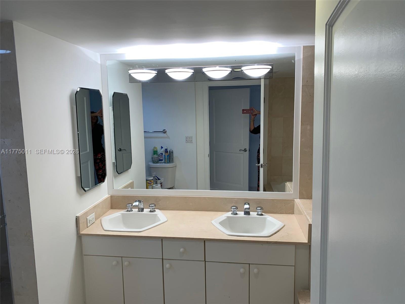 8855 Collins Avenue, Unit 5B Surfside, FL 33154 - Photo 22 of 35 a bathroom with a sink and a mirror