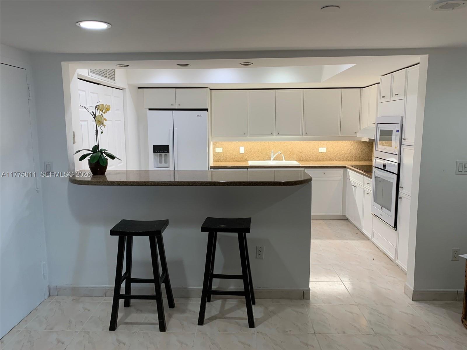 8855 Collins Avenue, Unit 5B Surfside, FL 33154 - Photo 3 of 35 a kitchen with a sink cabinets and window