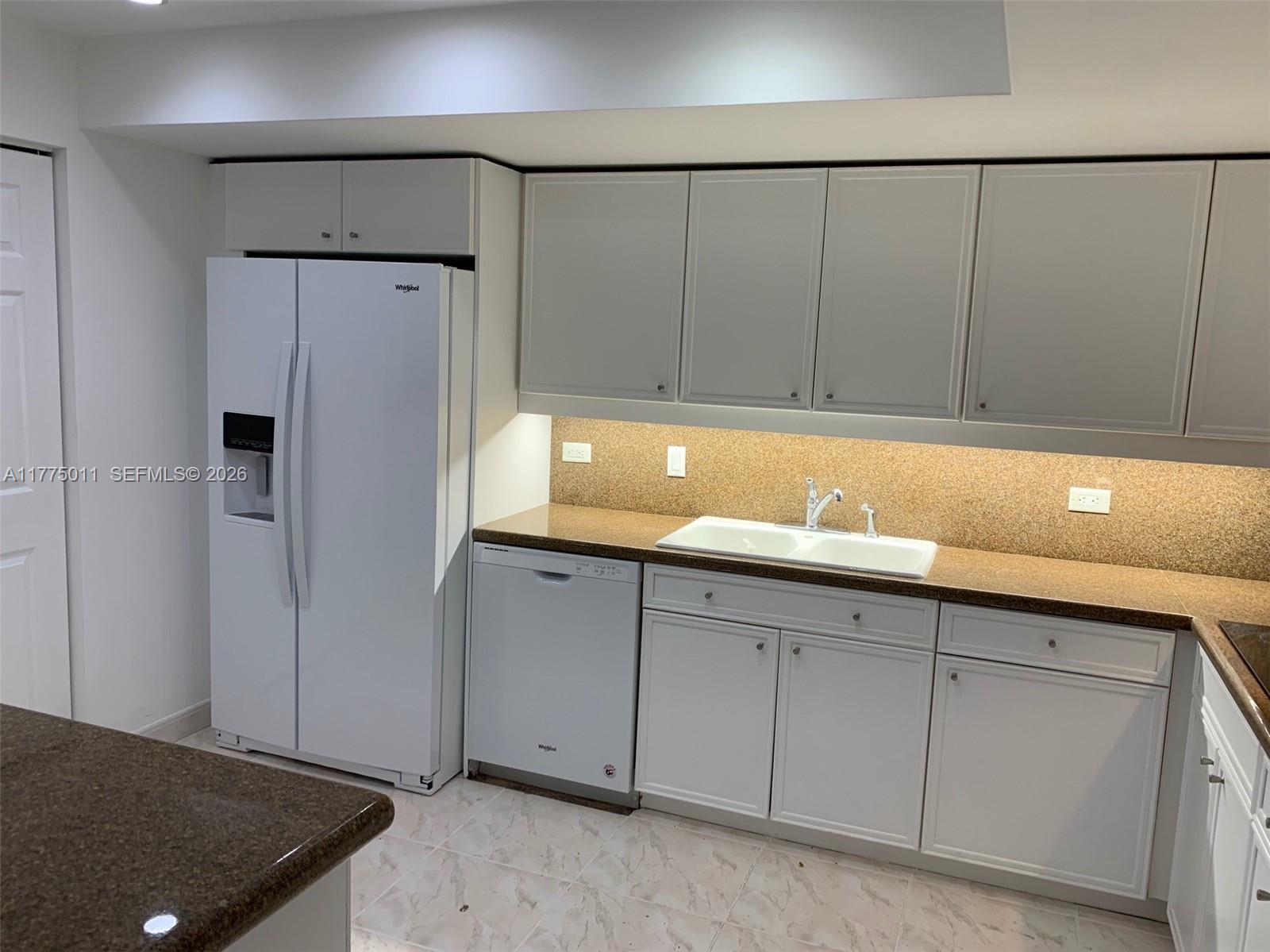 8855 Collins Avenue, Unit 5B Surfside, FL 33154 - Photo 7 of 35 a kitchen with a sink and cabinets