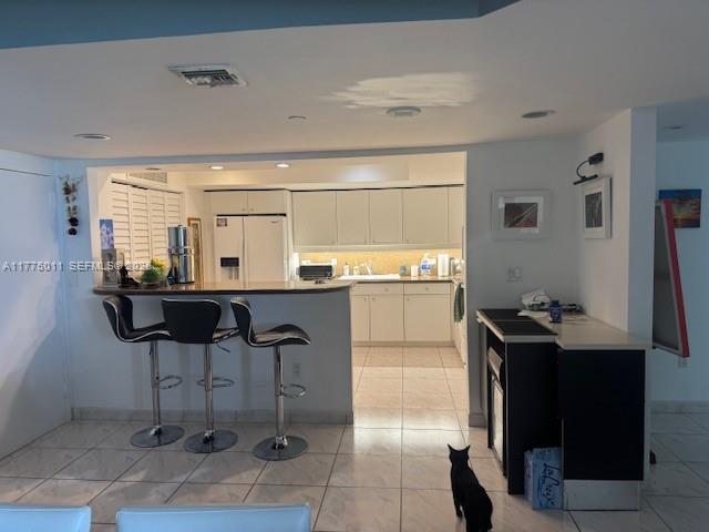 8855 Collins Avenue, Unit 5B Surfside, FL 33154 - Photo 10 of 35 a kitchen with stainless steel appliances kitchen island granite countertop a table and chairs in it