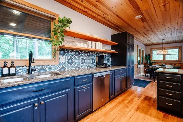 a kitchen with stainless steel appliances granite countertop wooden cabinets and sink