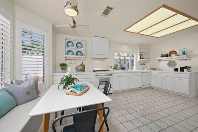 a kitchen with a table chairs stove and white cabinets