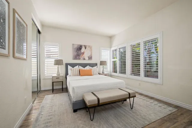 a bedroom with a bed a table and a large window