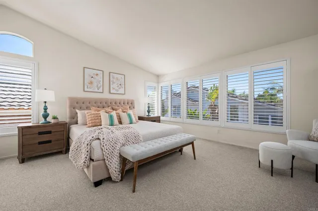 a spacious bedroom with a bed and a couch next to a window