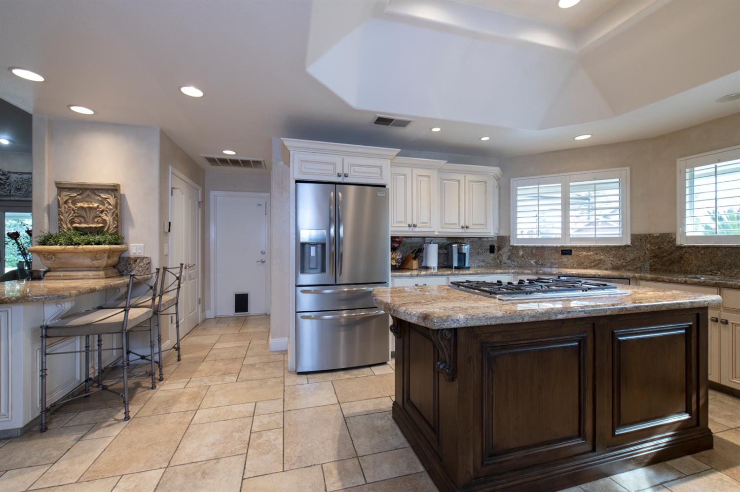 2873 Carolina Avenue Clovis, CA 93611 - Photo 2 of 23 a kitchen with granite countertop a stove and a refrigerator