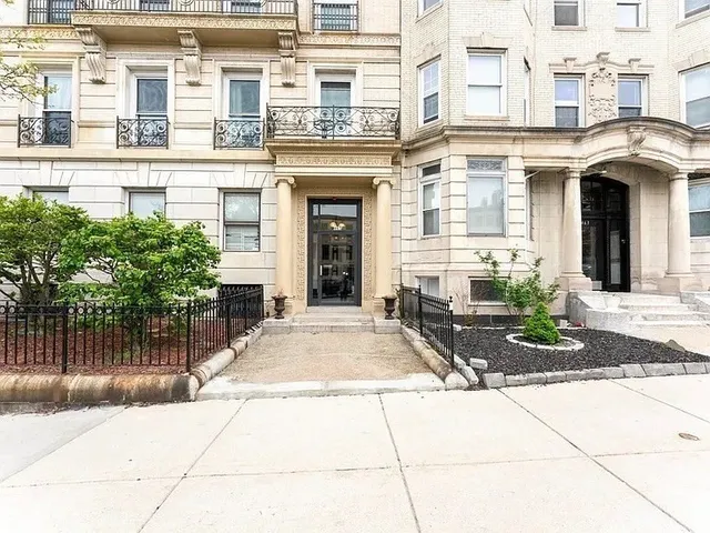 front view of a brick house with a bench in front of it