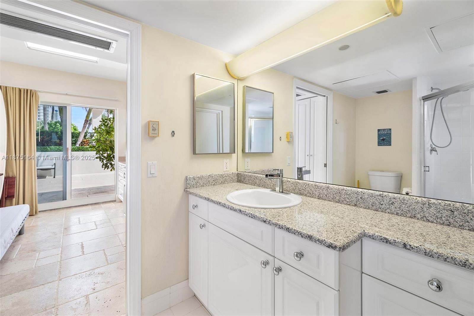 4775 Collins Avenue, Unit CAA14 Miami Beach, FL 33140 - Photo 2 of 4 a bathroom with a granite countertop sink and a mirror