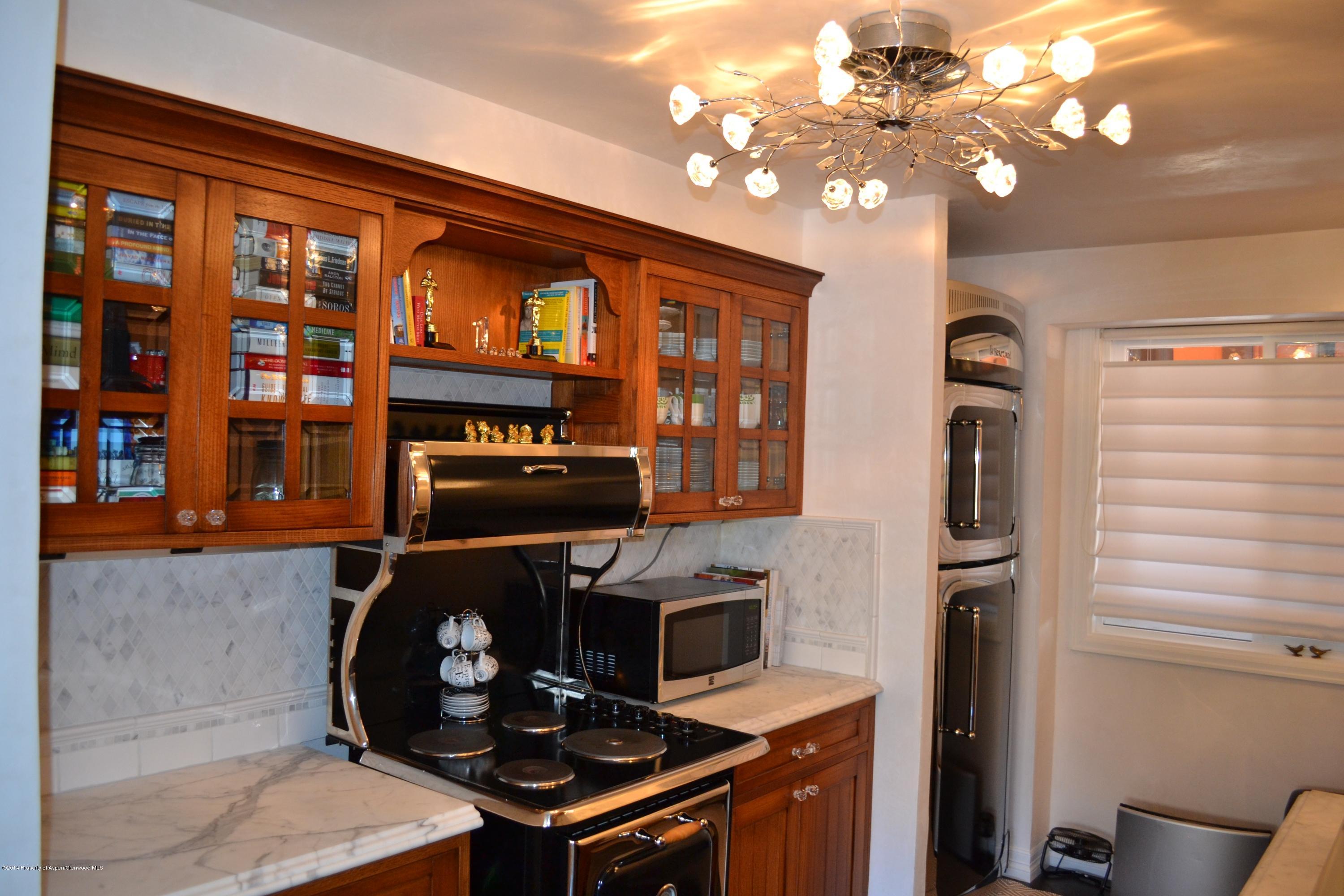 1041 Vine Street Aspen, CO 81611 - Photo 8 of 16 a kitchen with a stove and a chandelier