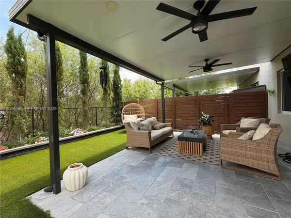 a living room with patio furniture and a floor to ceiling window