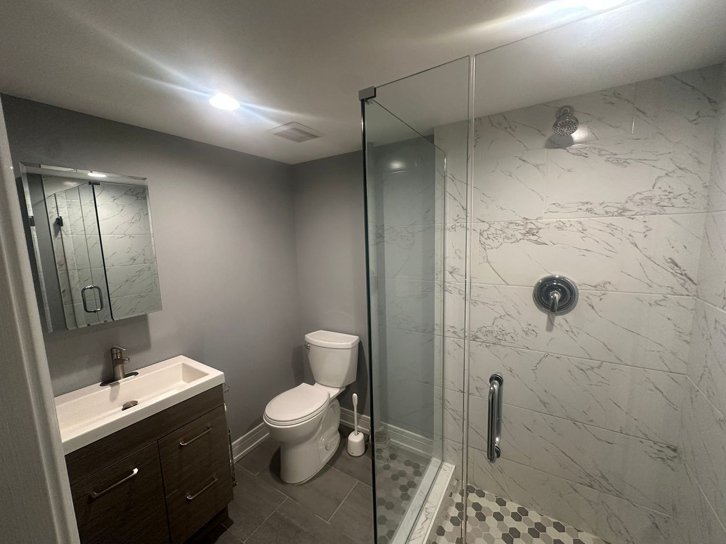 2543 Crawford Avenue, Unit 2543 Evanston, IL 60201 - Photo 11 of 17 a bathroom with a toilet a sink a mirror and shower