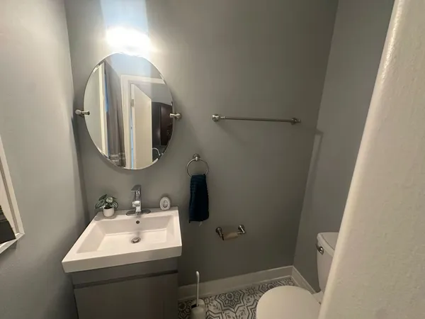 a bathroom with a toilet sink and mirror
