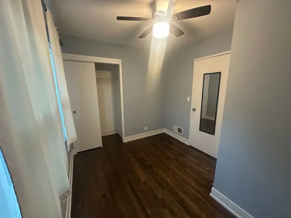 an empty room with wooden floor and closet