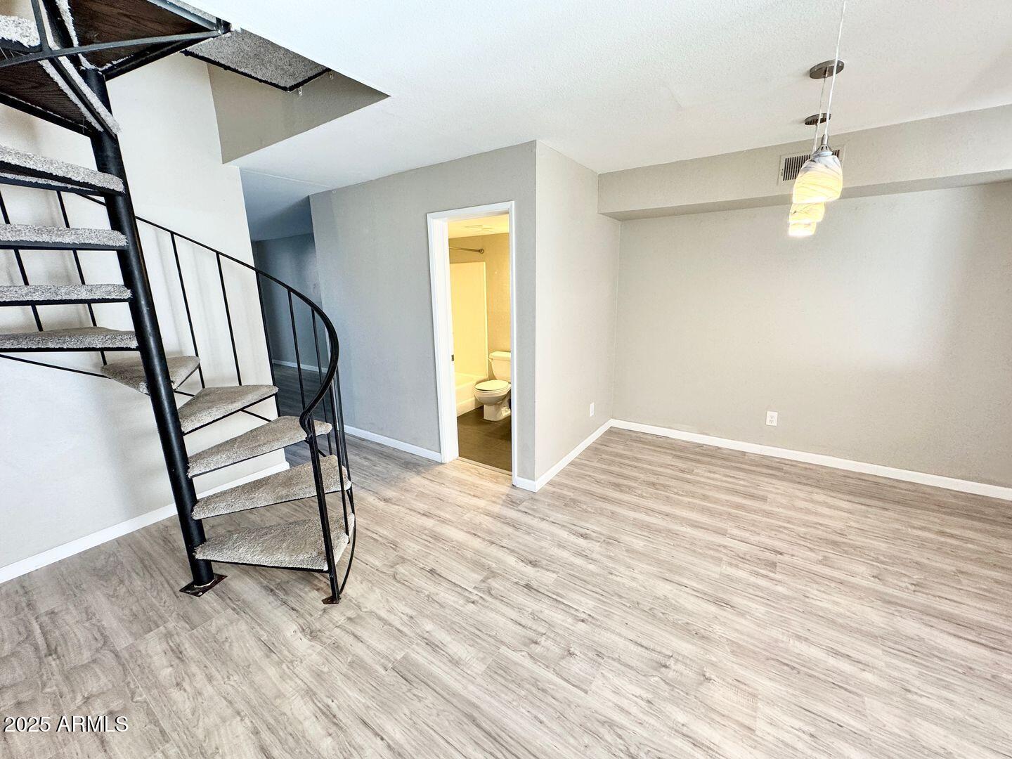 1425 East Desert Cove Avenue, Unit 2 Phoenix, AZ 85020 - Photo 12 of 42 a view of an empty room with a window and wooden floor