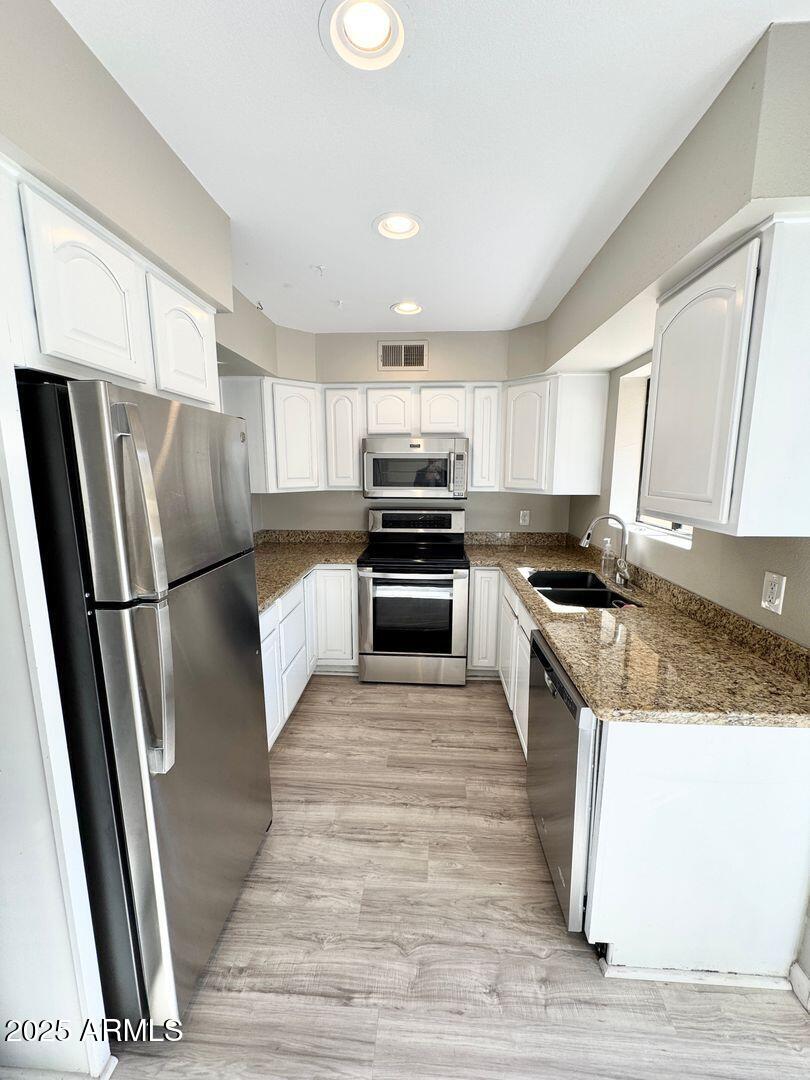 1425 East Desert Cove Avenue, Unit 2 Phoenix, AZ 85020 - Photo 17 of 42 a kitchen with granite countertop a refrigerator a sink a stove a microwave and island