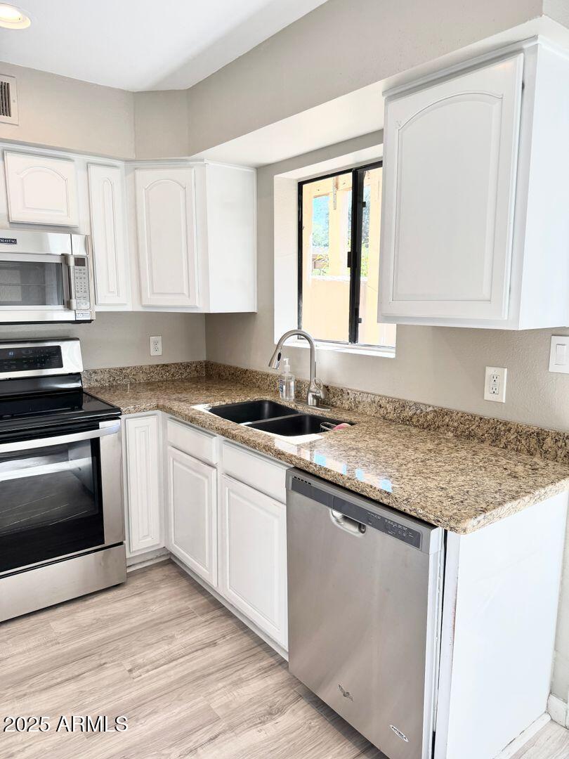 1425 East Desert Cove Avenue, Unit 2 Phoenix, AZ 85020 - Photo 18 of 42 a kitchen with granite countertop a sink stove and cabinets