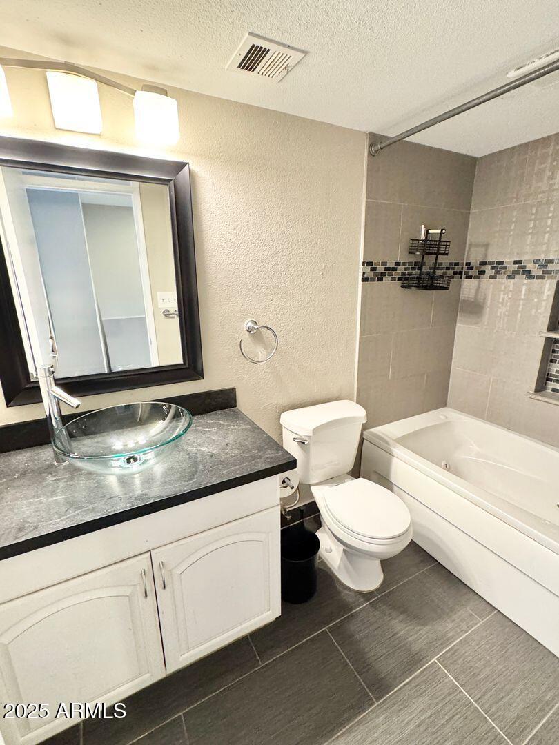 1425 East Desert Cove Avenue, Unit 2 Phoenix, AZ 85020 - Photo 33 of 42 a bathroom with a granite countertop toilet a sink and a mirror