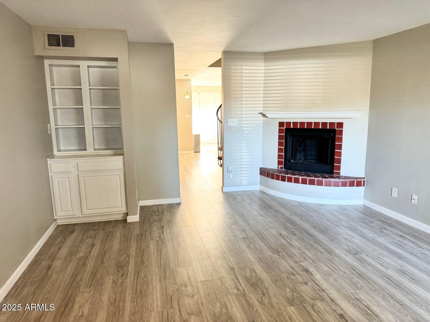 1425 East Desert Cove Avenue, Unit 2 Phoenix, AZ 85020 - Photo 8 of 42 a view of empty room with wooden floor and fireplace