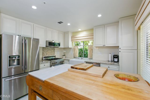 a kitchen with stainless steel appliances granite countertop a refrigerator sink and stove