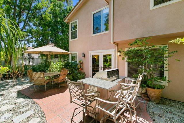 a view of a patio with furniture and table under an umbrella