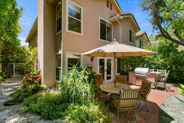 a patio with a table and chairs under an umbrella