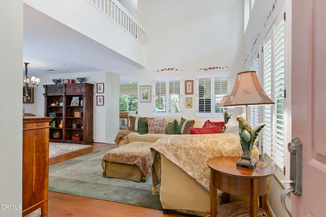 a living room with furniture a rug and a bookshelf