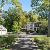 a front view of a house with a yard and green space