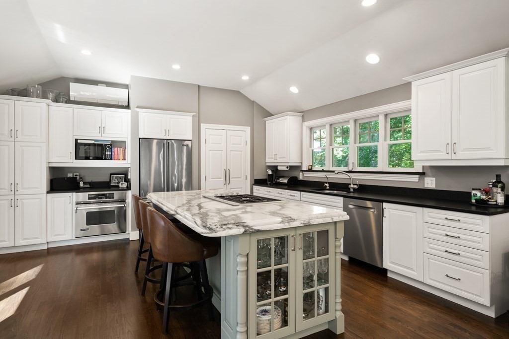 88 Pine Street Dover, MA 02030 - Photo 12 of 40 a kitchen with stainless steel appliances kitchen island granite countertop a table chairs sink refrigerator and cabinets