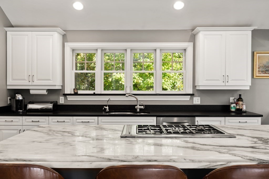 88 Pine Street Dover, MA 02030 - Photo 15 of 40 a kitchen with granite countertop a stove a sink and a white cabinets