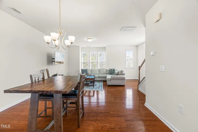 a view of a dining room with furniture wooden floor and chandelier