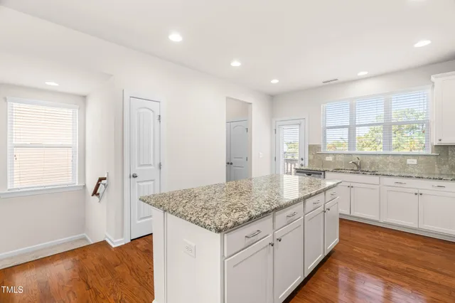 a kitchen with granite countertop kitchen island white cabinets and sink