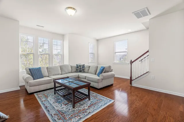a living room with furniture a rug and a wooden floor