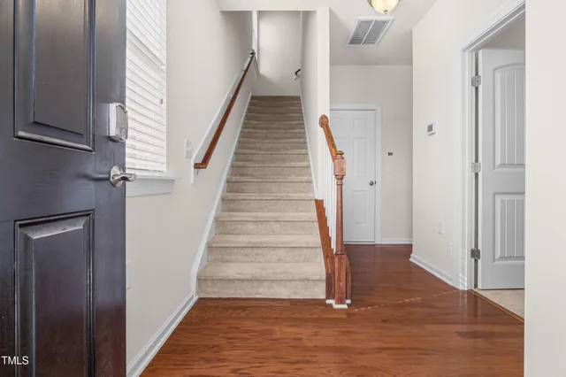 a view of a hallway with wooden floor and entryway