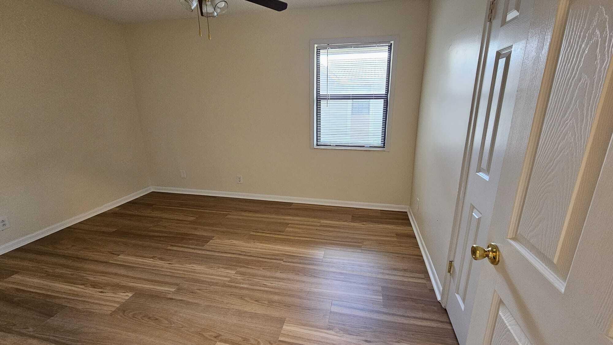8801 West Sample Road, Unit 11 Coral Springs, FL 33065 - Photo 14 of 25 a view of an empty room with wooden floor and a window