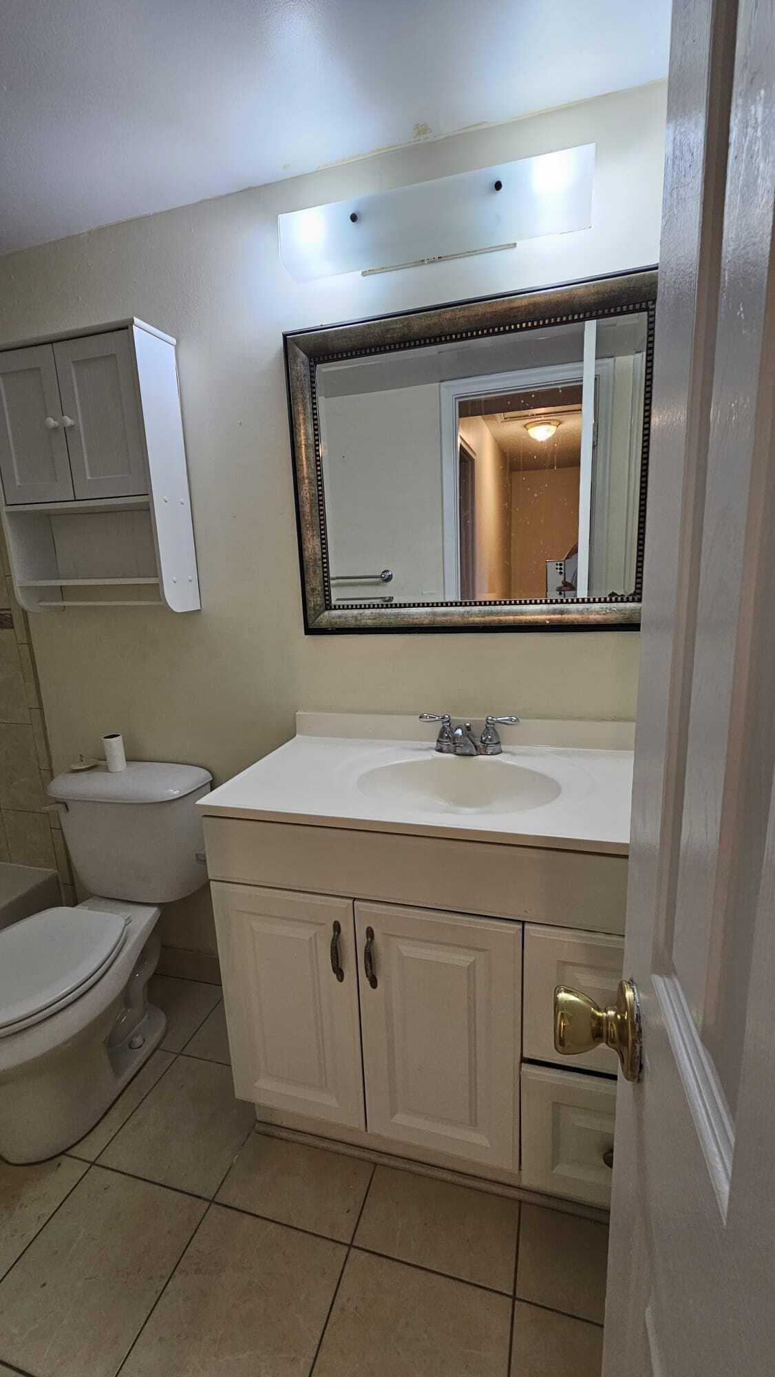 8801 West Sample Road, Unit 11 Coral Springs, FL 33065 - Photo 16 of 25 a bathroom with a sink toilet and mirror