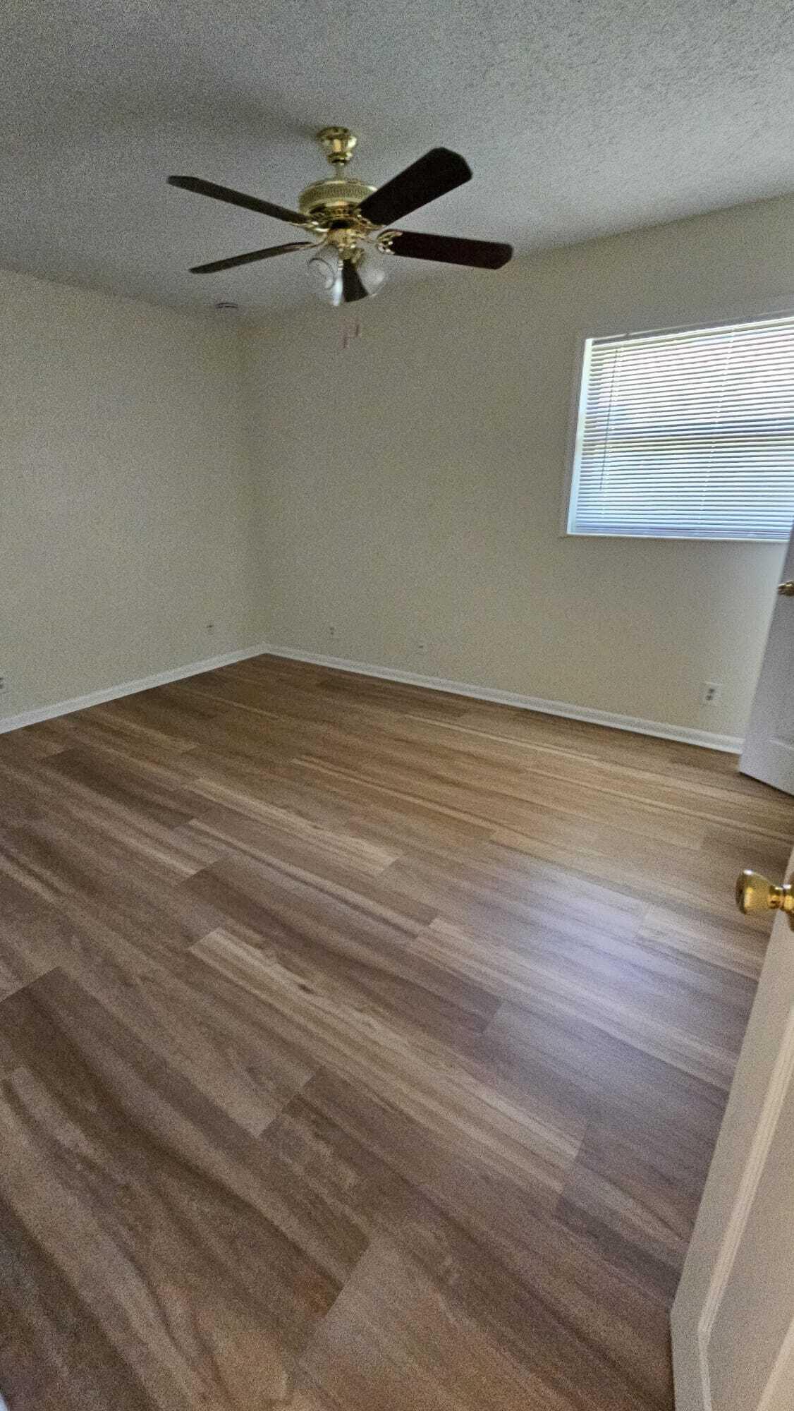 8801 West Sample Road, Unit 11 Coral Springs, FL 33065 - Photo 10 of 25 a view of a room with wooden floor fan and windows