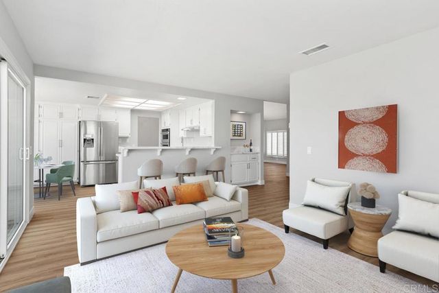 a living room with furniture kitchen view and a rug
