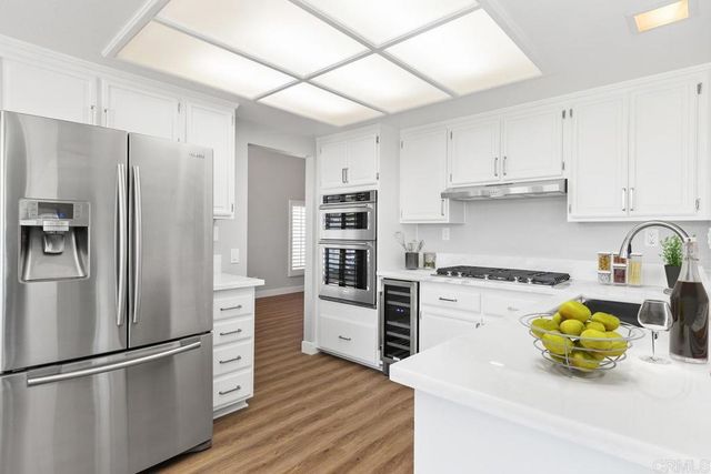 a kitchen with stainless steel appliances a stove a refrigerator and a cabinets