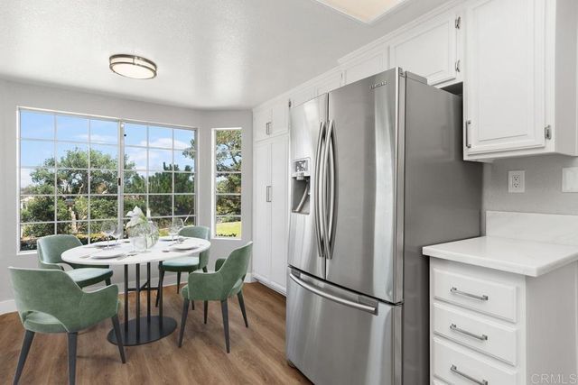 a kitchen with windows and refrigerator