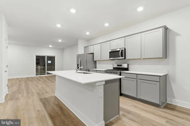 a kitchen with kitchen island a sink stainless steel appliances and cabinets