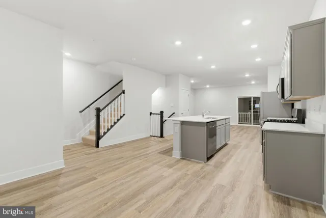 a view of living room with kitchen island stainless steel appliances wooden floor and view living room