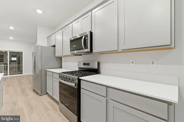 a kitchen with stainless steel appliances white cabinets and a stove