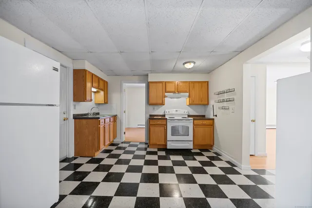 a room with a black white checkered floor with a black white checkered floor and a flat screen tv