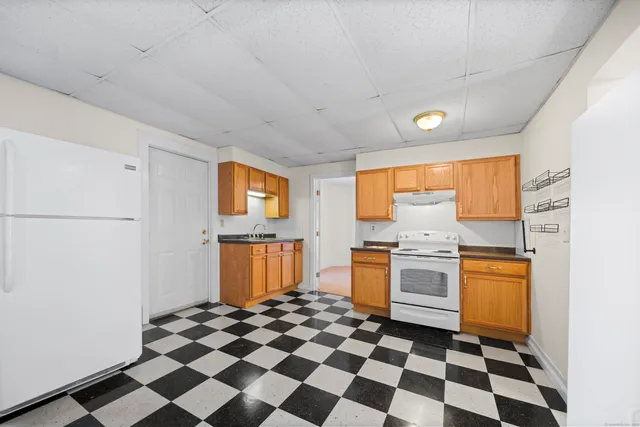 a kitchen with a checkered floor and white cabinets