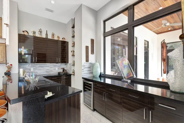 a kitchen with stainless steel appliances granite countertop a sink and a large window