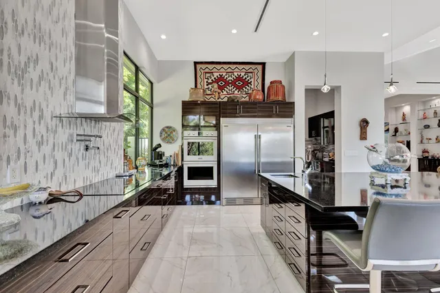 a kitchen with stainless steel appliances kitchen island granite countertop a refrigerator and a stove